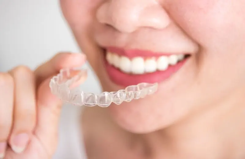 Patient wearing Invisalign clear aligners provided by Recreate Smiles Joondalup